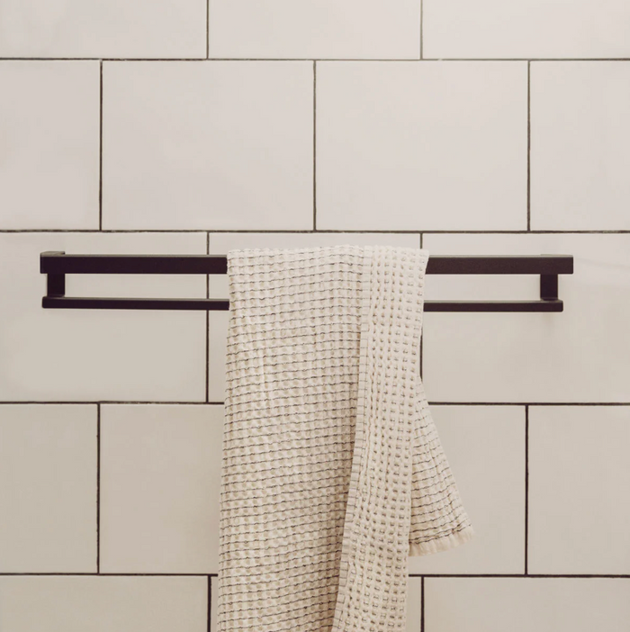 KANSO Towel Holder in Graphite powder-coated steel mounted on a small bathroom wall by ATYP Slovakia
