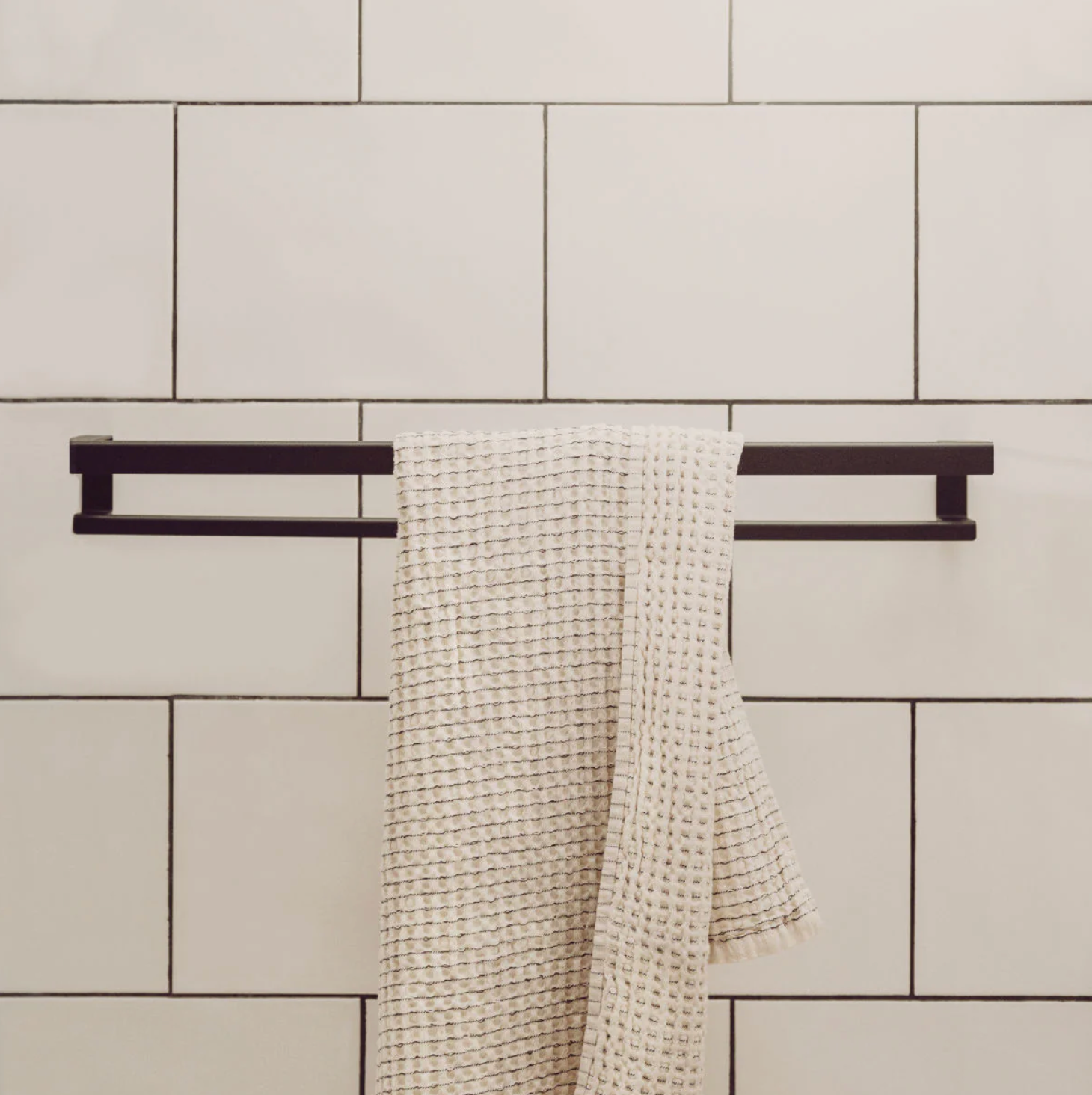 KANSO Towel Holder in Graphite powder-coated steel mounted on a small bathroom wall by ATYP Slovakia