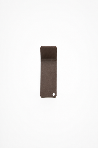 CORE wall hook in Umber powder coated steel, RAL 8022, studio front view with folded lip and punched corner hole