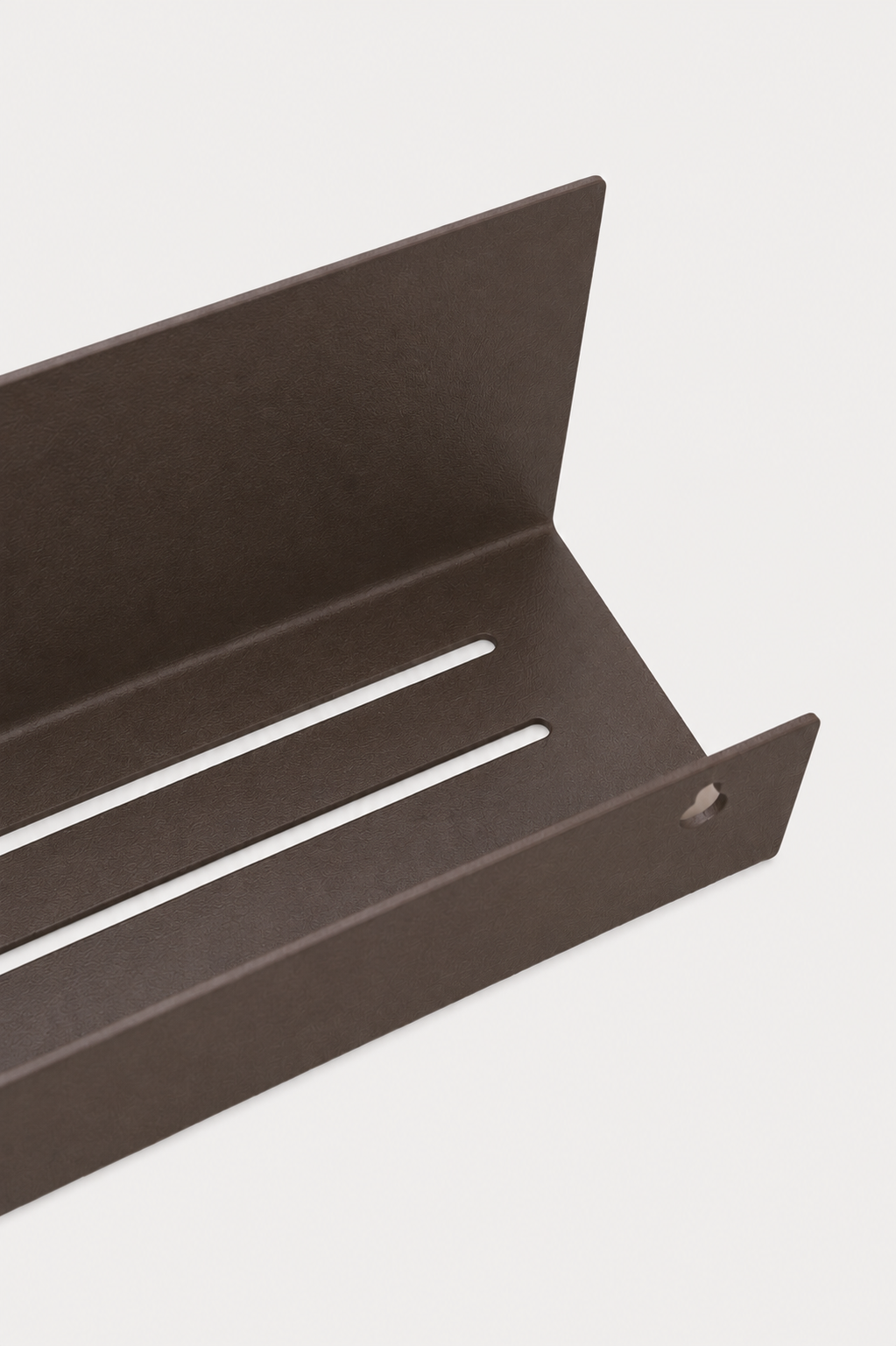 METI bathroom shelf in Umber powder coated steel, RAL 8022, angled close-up of the slotted drainage tray, dark warm brown