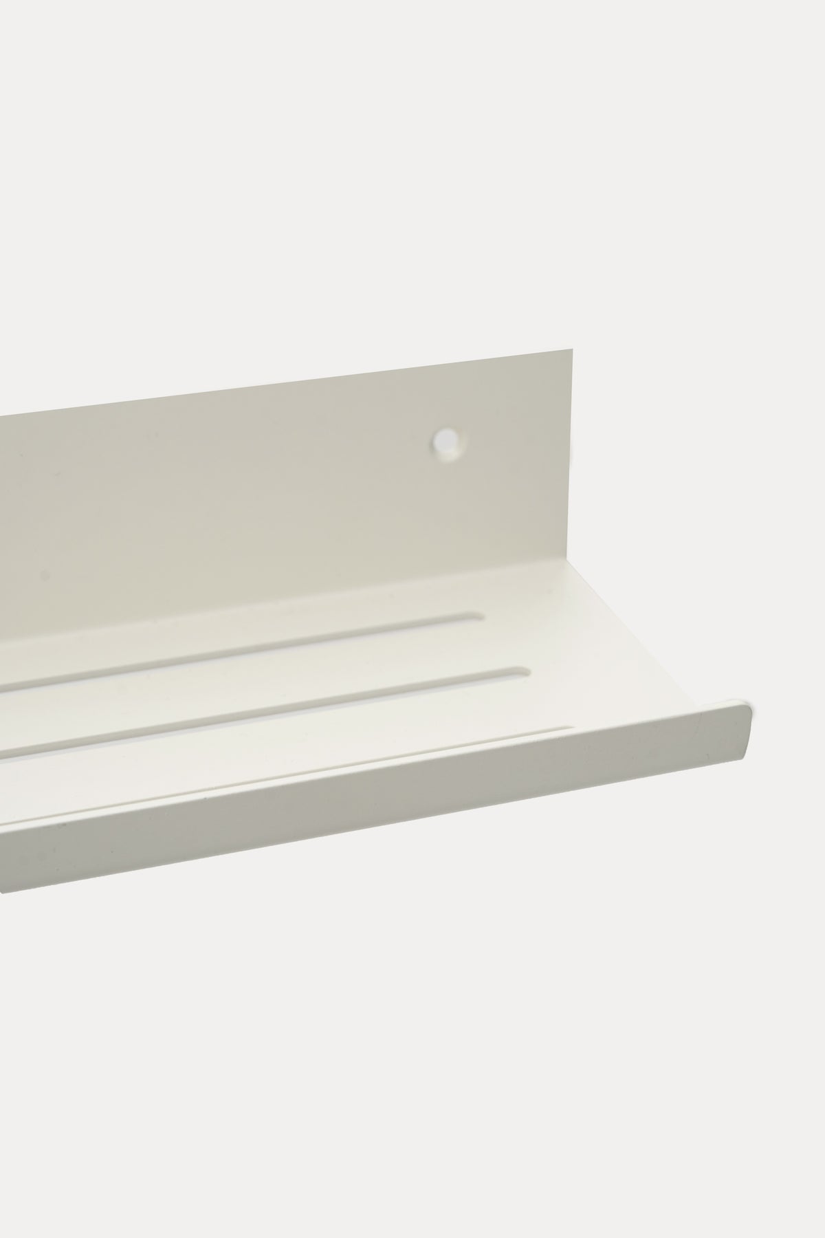 ELIORA shower shelf in Chalk powder coated steel, close-up of the slotted tray, bright white, lip at the front edge