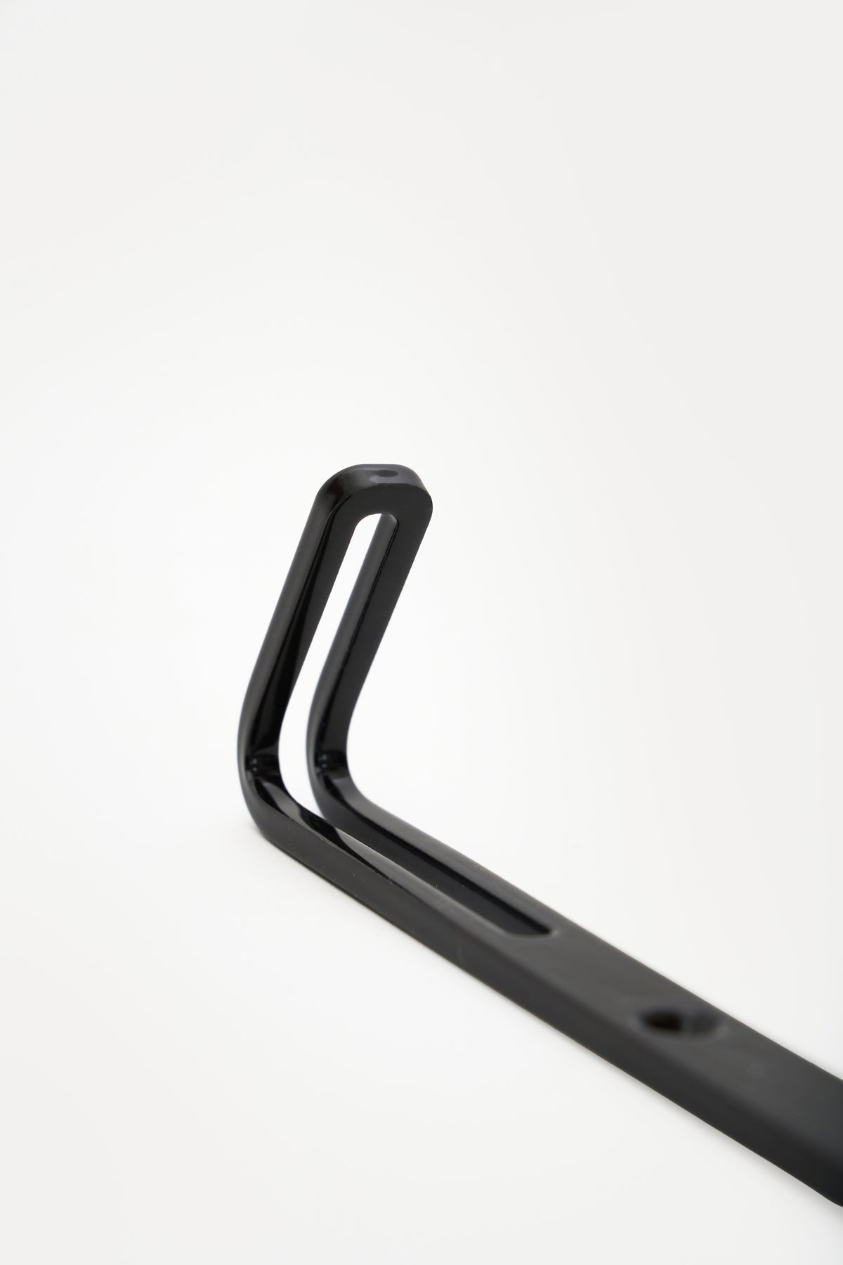 AIKI wall hook in powder coated steel, angled macro of the forked prong top and slot, jet black