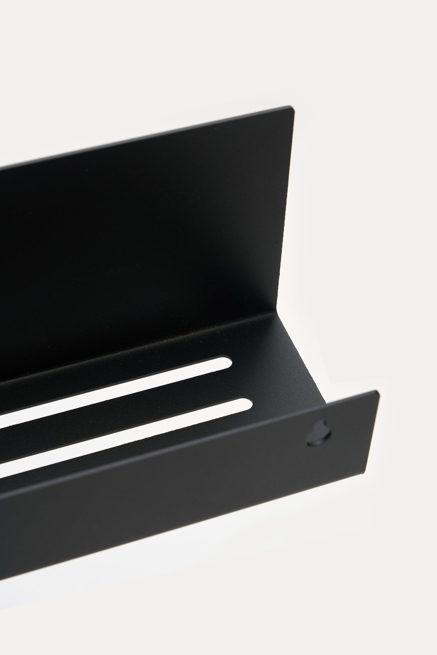 METI bathroom shelf in Graphite powder coated steel, angled close-up of the slotted drainage tray, jet black
