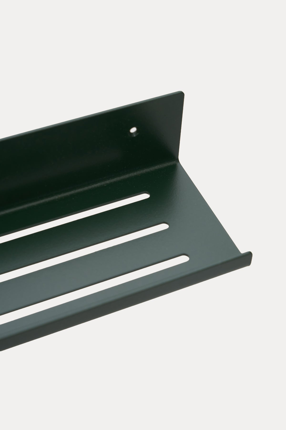 ELIORA shower shelf in powder coated steel, angled close-up of the slotted tray in a deep green powder coat, a custom RAL shade