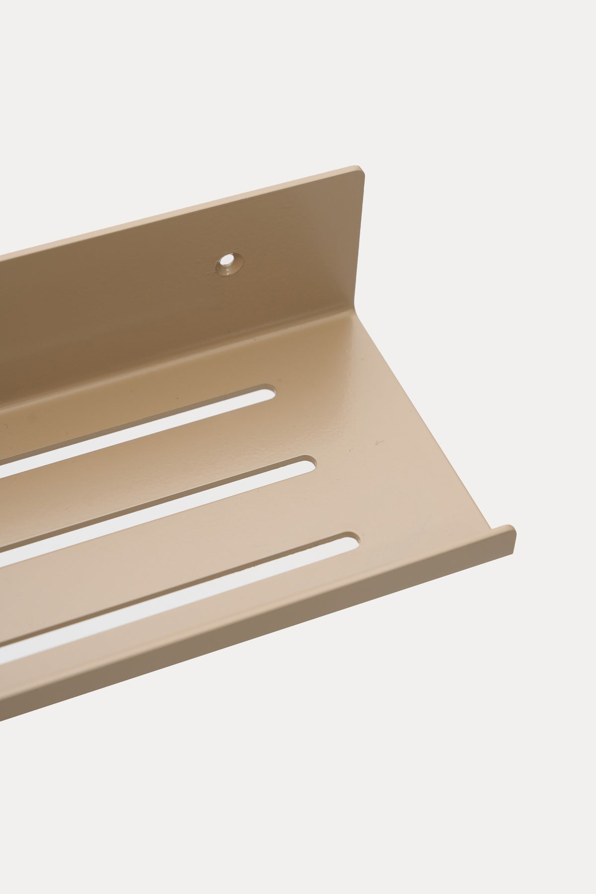 ELIORA shower shelf in Linen powder coated steel, RAL 1019, close-up of the slotted tray, warm beige, mount hole visible