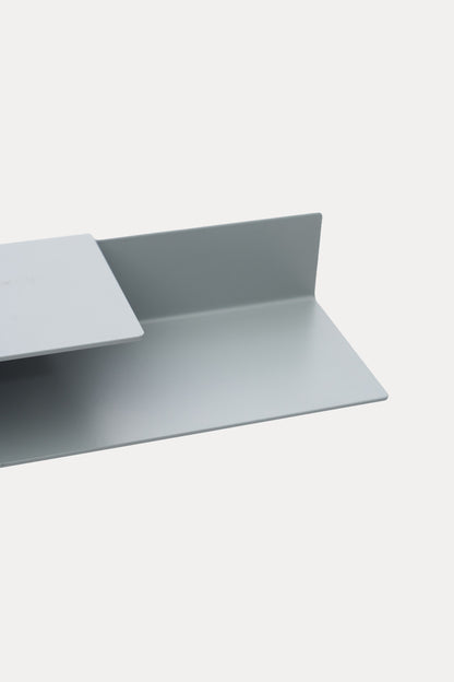 NYVE toilet paper holder in powder coated steel, close-up of the top shelf and back panel in a pale grey powder coat