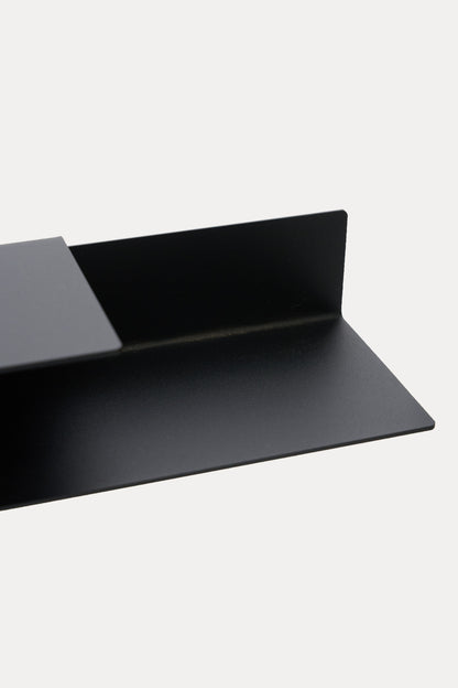 NYVE toilet paper holder in powder coated steel, wide close-up of the shelf and hook arm with roll slot, deep black with a soft sheen