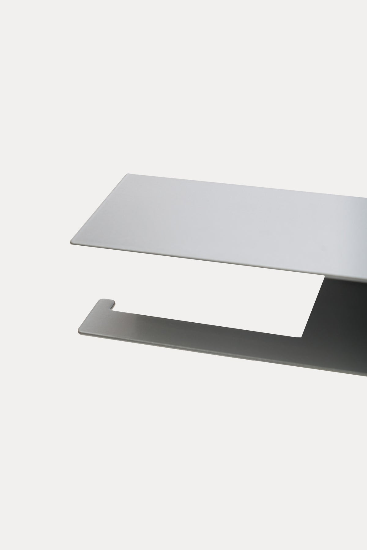 NYVE toilet paper holder in powder coated steel, close-up of the top shelf and hook arm in a pale grey powder coat, second angle