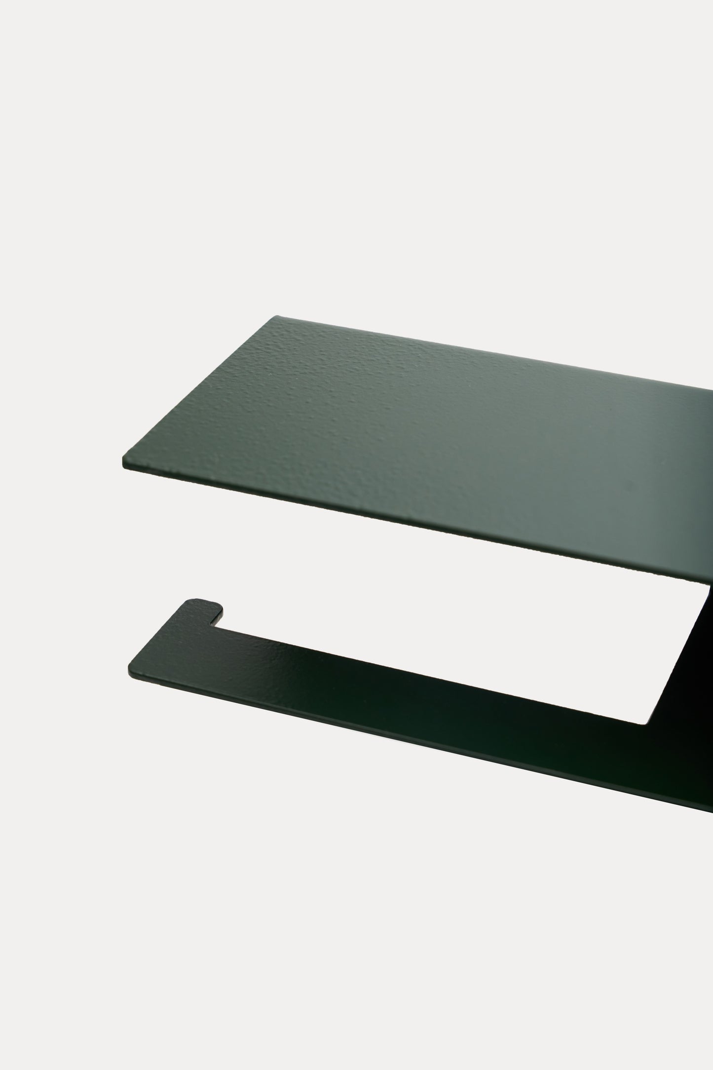 NYVE toilet paper holder in powder coated steel, close-up of the top shelf and hook arm in a deep green powder coat, a custom RAL shade