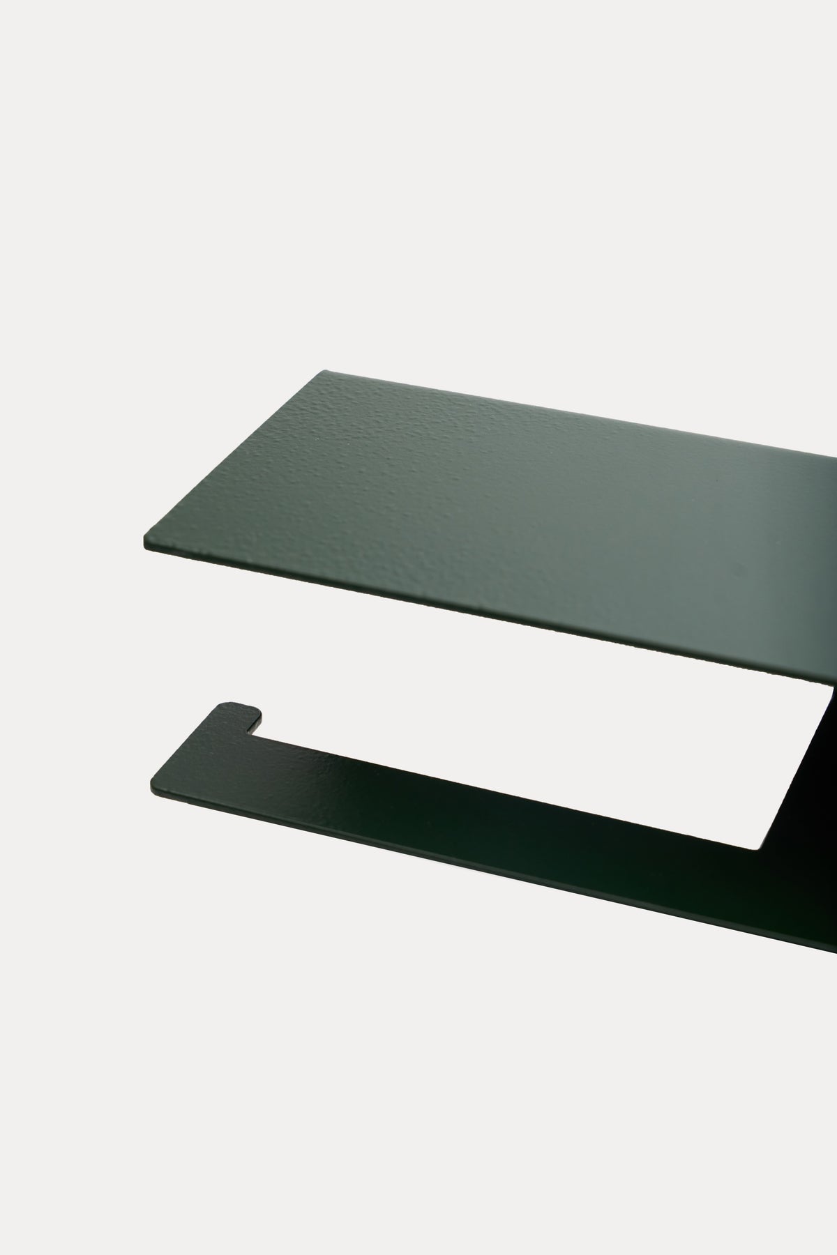 NYVE toilet paper holder in powder coated steel, close-up of the top shelf and hook arm in a deep green powder coat, a custom RAL shade