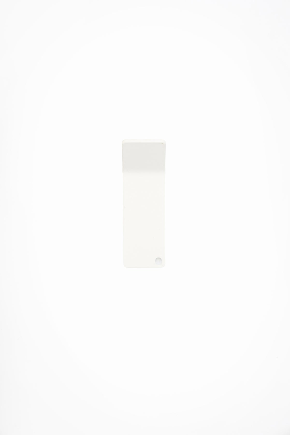 CORE wall hook in Chalk powder coated steel, front view of the tape-mount hook, soft white, punched corner hole