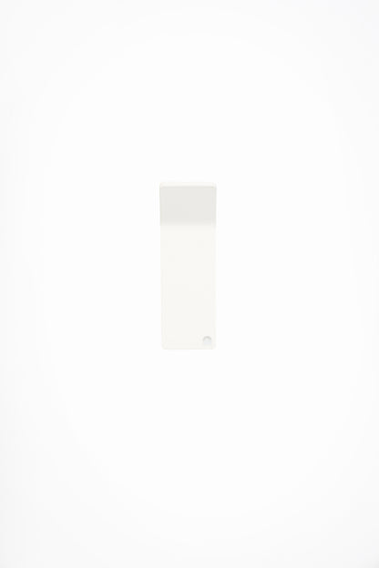 CORE wall hook in Chalk powder coated steel, front view of the tape-mount hook, soft white, punched corner hole