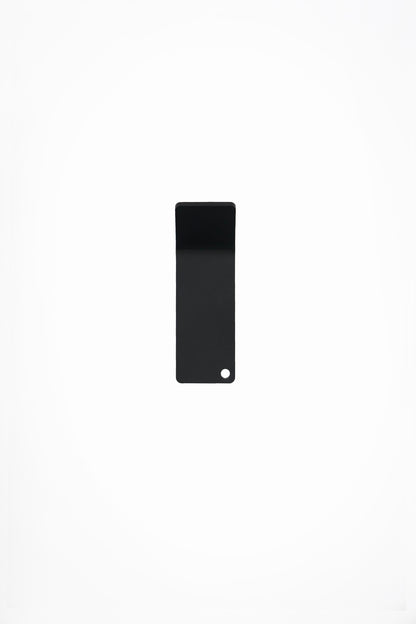 CORE wall hook in Graphite powder coated steel, front view of the tape-mount hook, jet black, punched corner hole