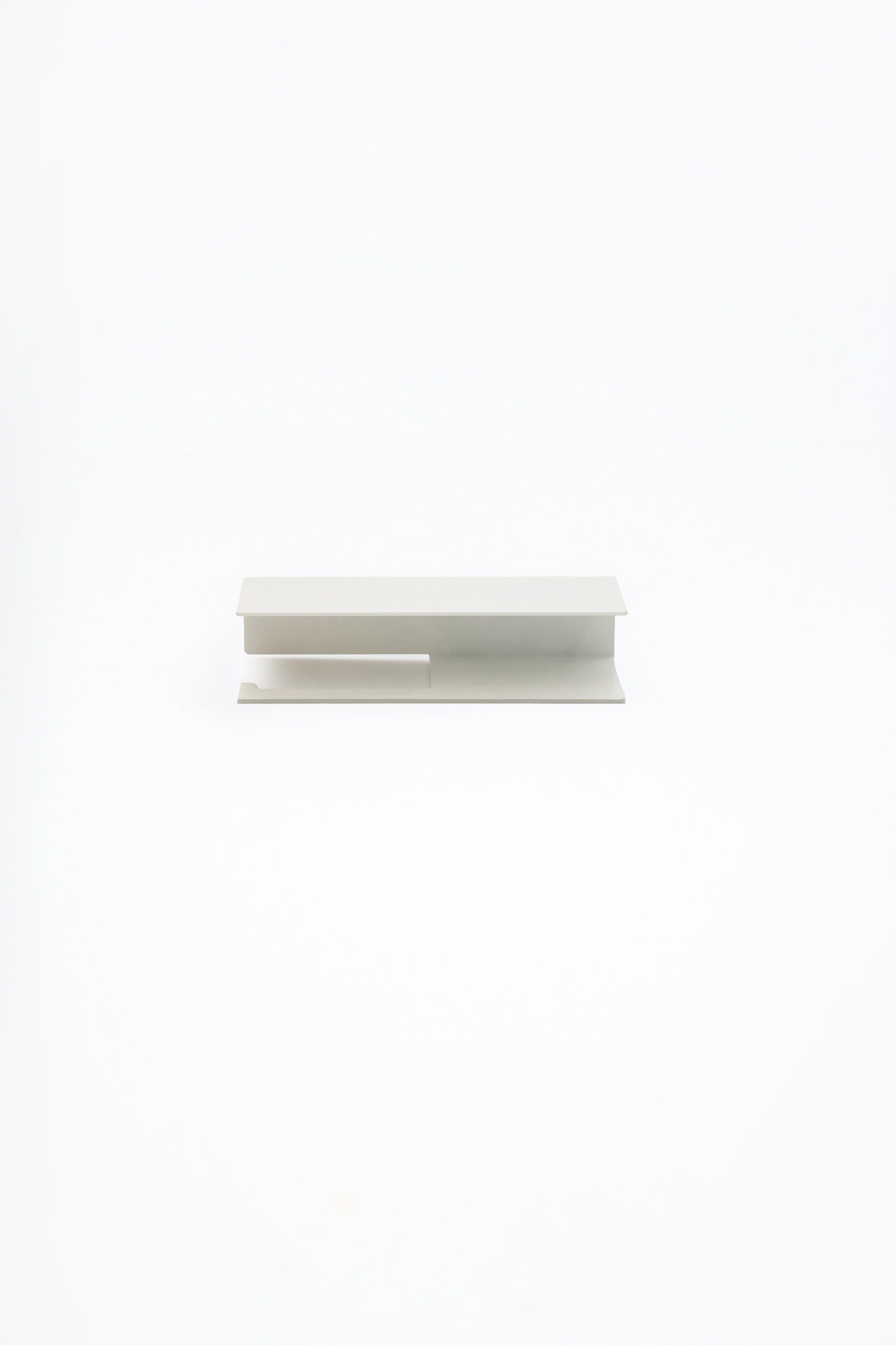 NYVE toilet paper holder in powder coated steel, full front view of the compact holder in a soft pale finish