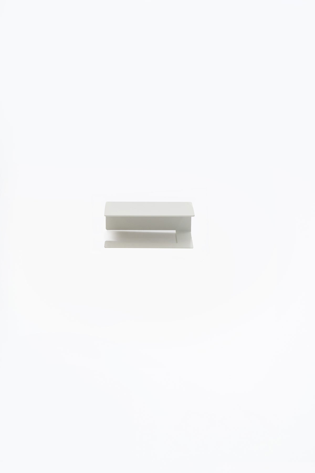 NYVE toilet paper holder in powder coated steel, full front view of the compact holder in a pale grey white finish