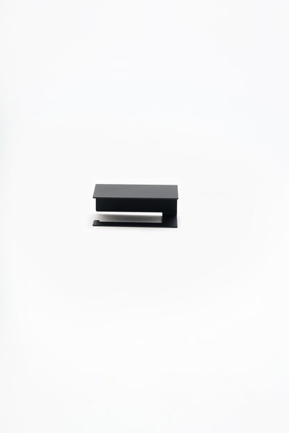 NYVE toilet paper holder in powder coated steel, straight studio front view of the holder, matte black