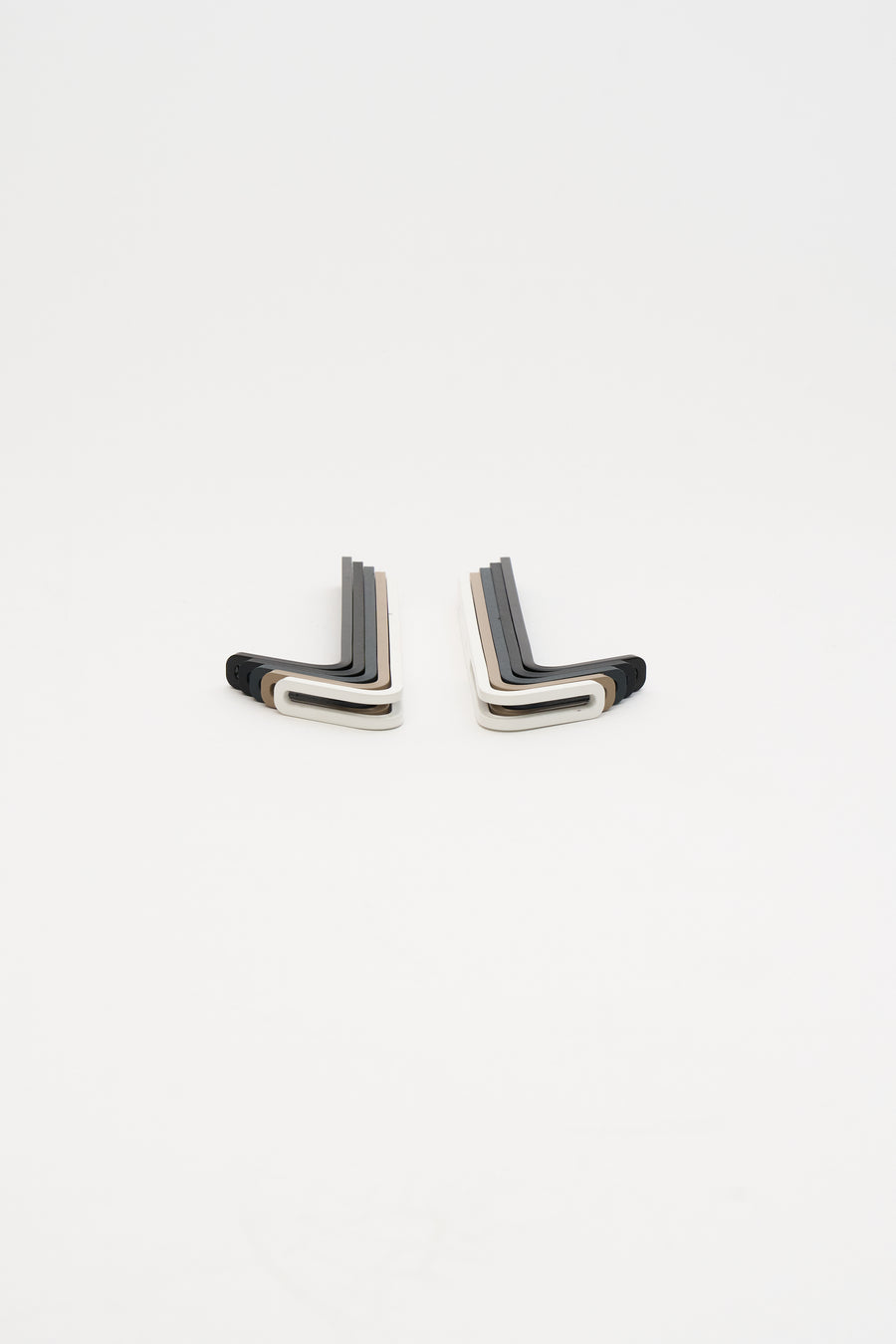 Two stacks of ATYP steel wall hooks in mixed powder coat finishes, photographed in the studio