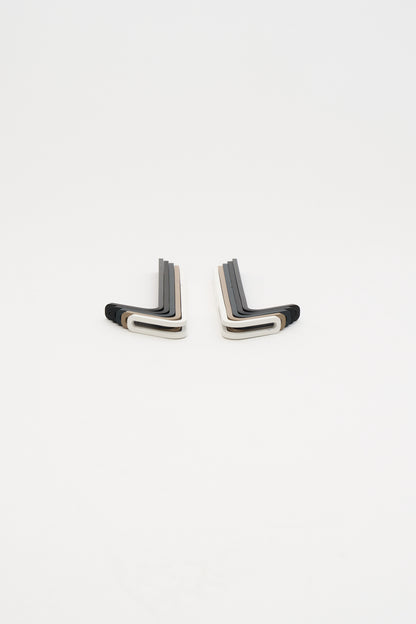 All five powder coat finishes of the hook fanned out in two mirrored stacks, studio flatlay, the ATYP AIKI wall hook