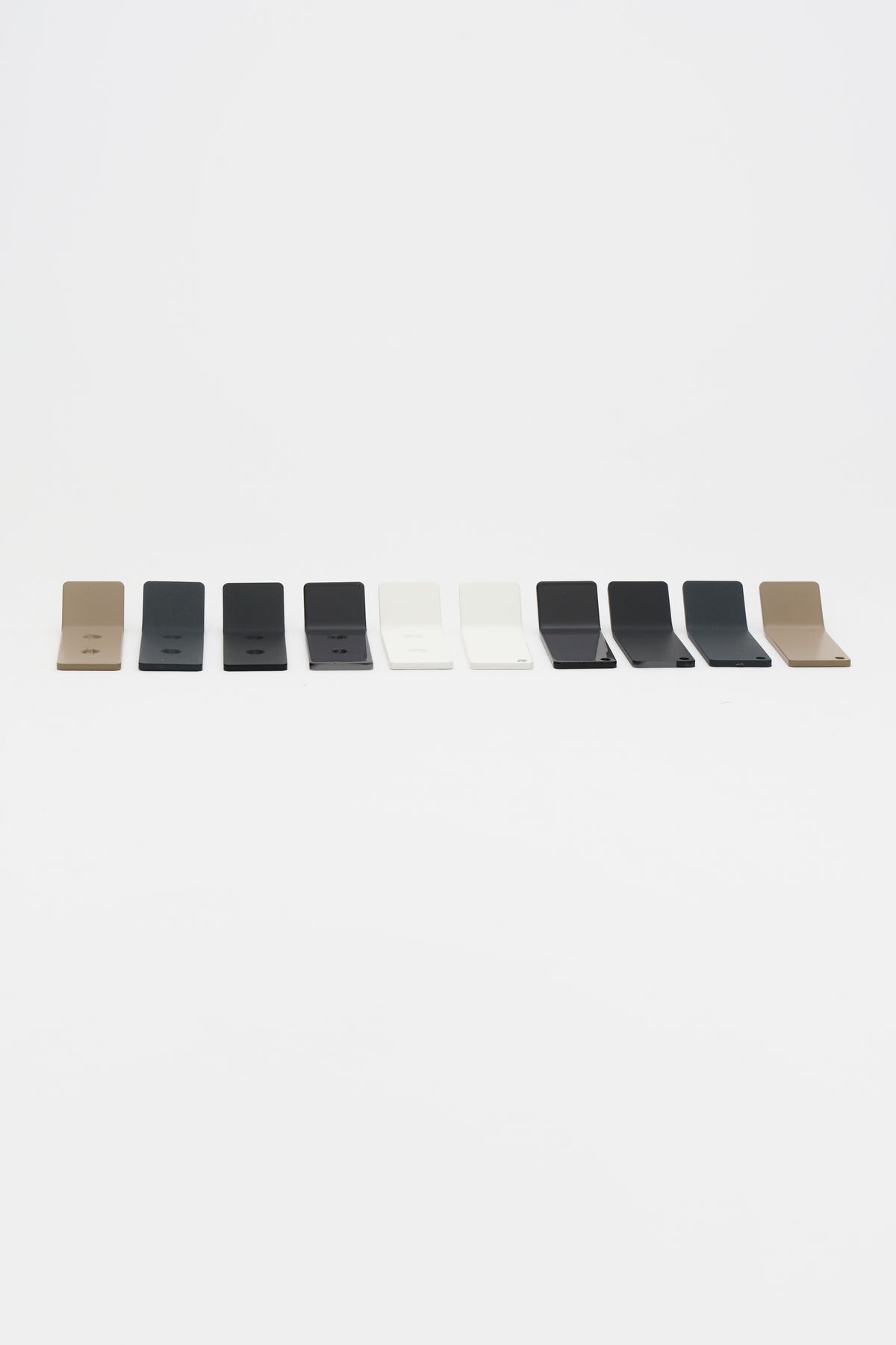 Ten ATYP steel wall hook samples in a row, showing the workshop powder coat finish range.